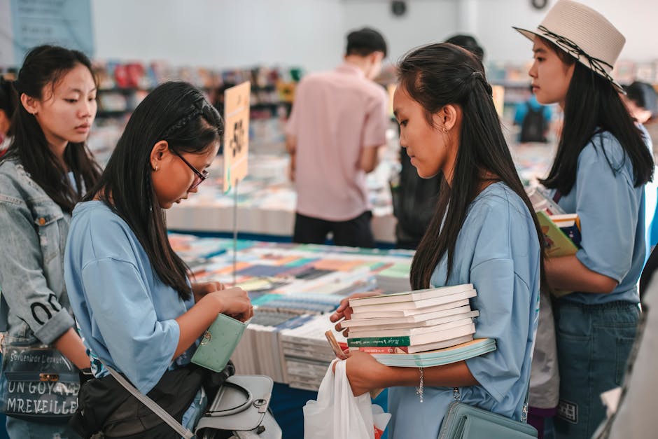 Student speaking with employers at a college career fair while holding a resume.