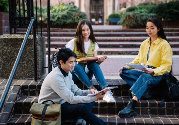 International Student Survival Guide: From Visa basics to campus enrollment steps shown on a university campus signboard