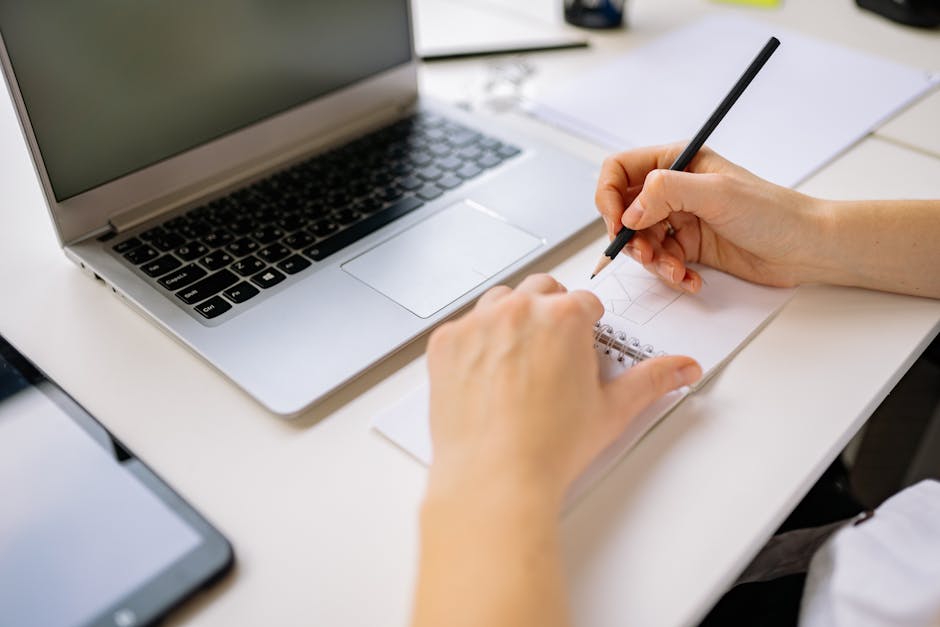 Student typing a personal statement draft while checking program prompts