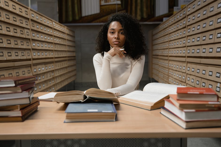Student using a laptop in a quiet library while searching for academic sources