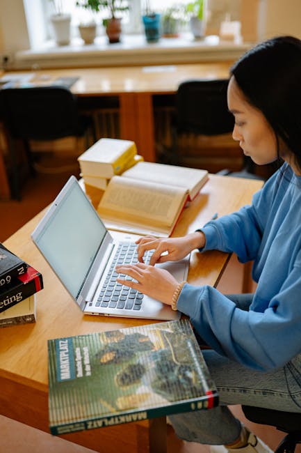 Student reviewing course registration on a laptop in a campus setting