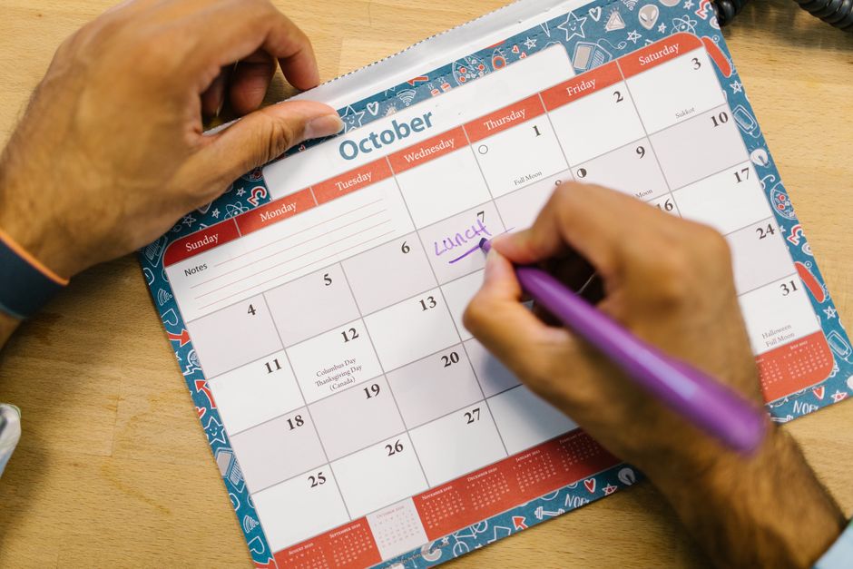 Close-up of a person planning a study and application timeline on a calendar