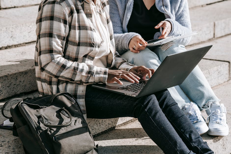 Students studying on laptops in a campus classroom, illustrating Campus vs. Online Learning comparison of outcomes and support