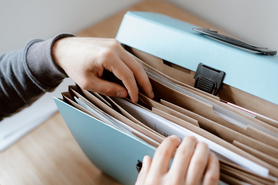 Student organizing application documents and folders on a desk