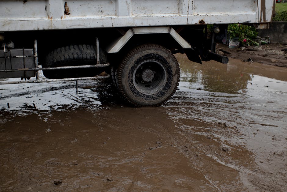 Heavy truck and muddy ground near pedestrian area illustrating risks of poor timing