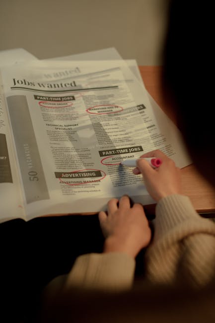 Laptop screen with job listings while a student compares market demand