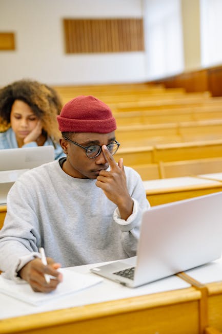 Student mapping course prerequisites on a laptop with notes and arrows