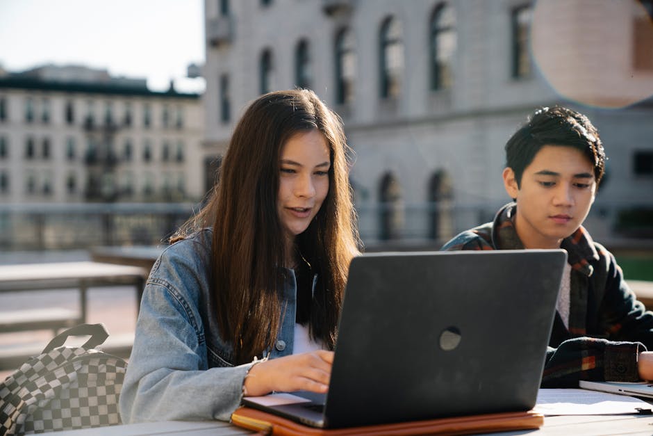 Student reviewing study app on laptop, with notes and flashcards nearby
