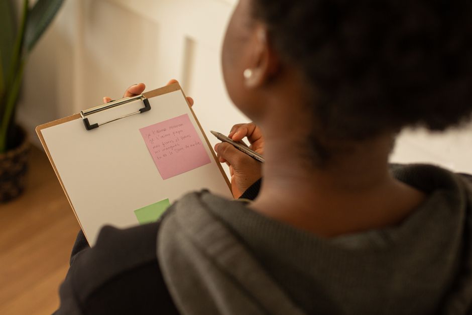 Person marking a checklist with a notebook while reviewing program requirements