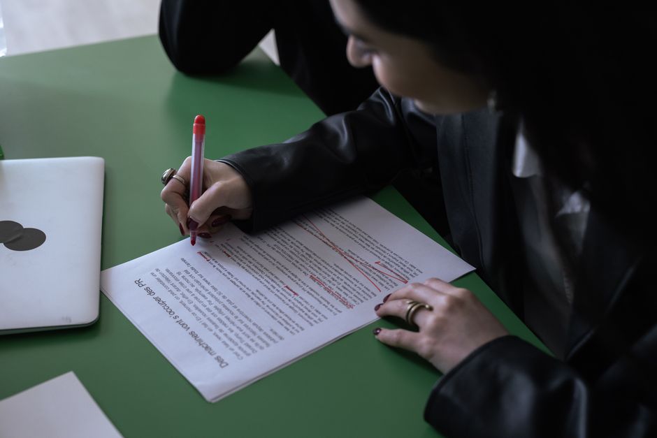 Student proofreading and editing an essay on a laptop at a desk